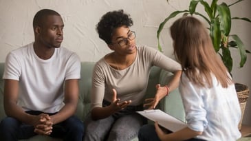 Two people sitting with a counselor during a conflict. 