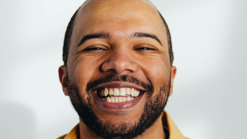 A closeup image of a person smiling at the camera